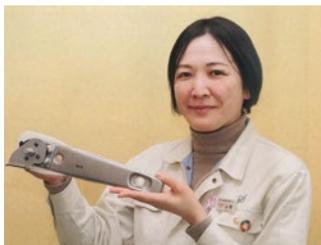 山根教代社長が製品を手に持っている写真