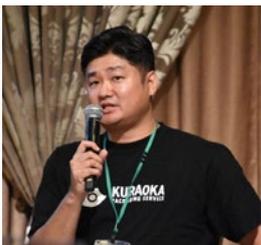 倉岡和徳社長がマイクを持って話している様子